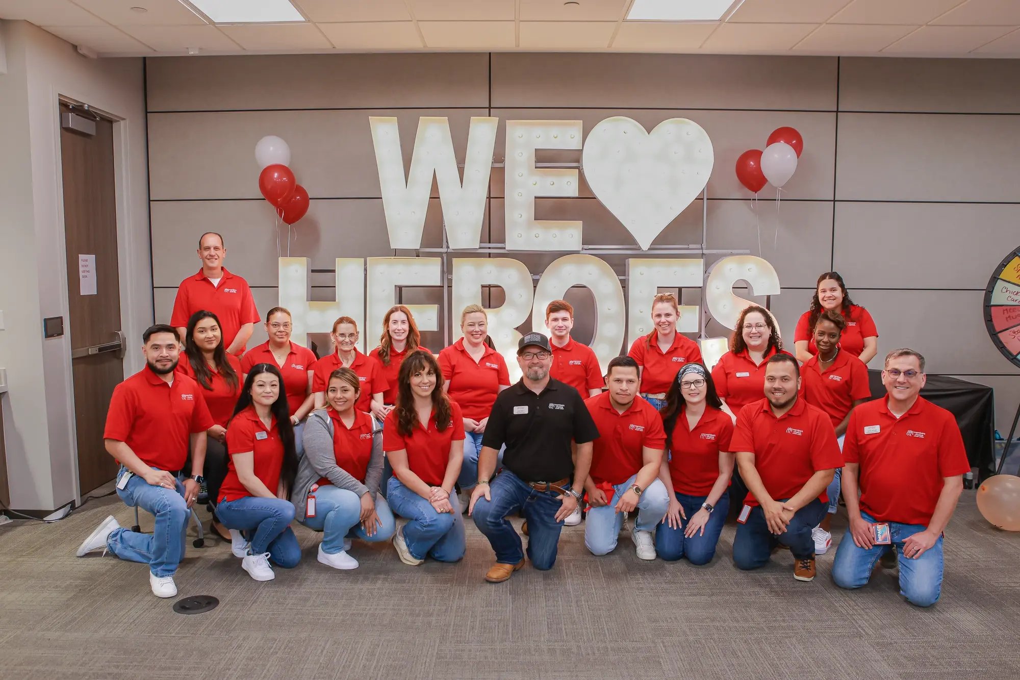 Group photo in front of 'we love heroes' sign